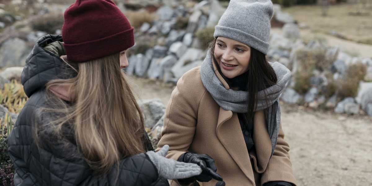 Två kvinnor sitter ute och pratar